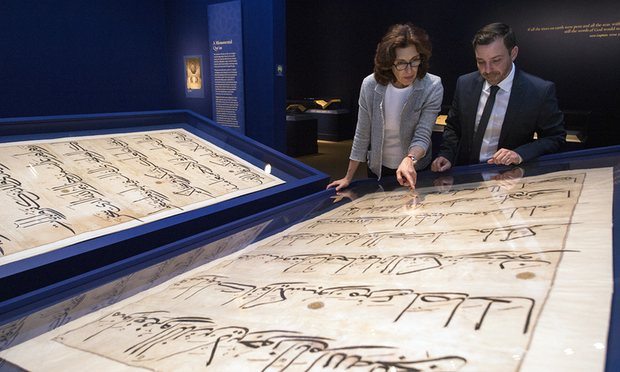 Massumeh Farhad and Simon Rettig, curators of the exhibit, look at pages from a 5x7 ft Quran.