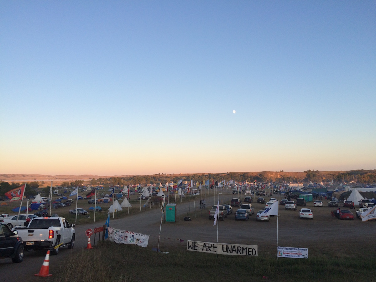 “We Are Unarmed” banner at the mouth of Oceti Sakowin/Red Warrior Camp (Photo: Nadya Tannous)